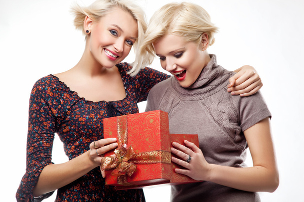 twee blonde schoonheden houden een kerstcadeau - Foto, afbeelding