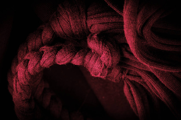 Texture, fond, motif. Tissu en tresses rouges. Fond tricoté tricoté avec motif gaufré. Tresses en tricot. - Photo, image