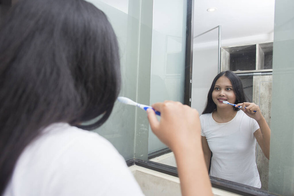 asiatique femme brosse ses dents dans la chambre - Photo, image