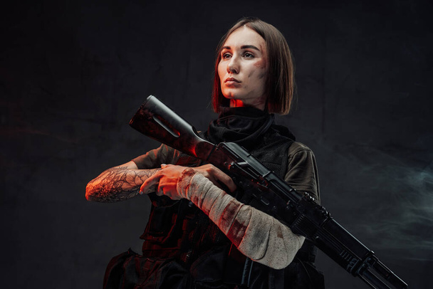 Kaunis sotilas nainen side käsi ja kivääri - Valokuva, kuva