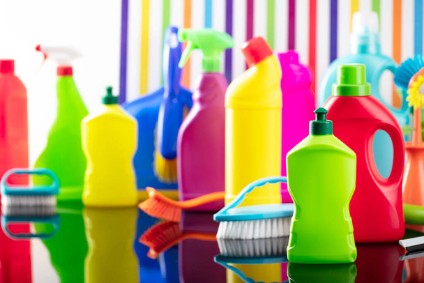 Spring house and office cleaning theme. Colorful set of bottles with clining liquids and colorful cleaning kit on background in the form of colorful stripes. - Photo, Image