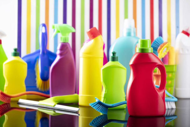Casa de primavera y oficina tema de limpieza. Colorido conjunto de botellas con líquidos y kit de limpieza de colores en el fondo en forma de rayas de colores. - Foto, imagen