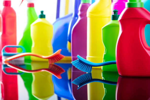 Spring house and office cleaning theme. Colorful set of bottles with clining liquids and colorful cleaning kit on background in the form of colorful stripes. - Photo, Image