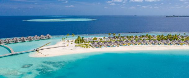 Güzel Maldivler cenneti tropikal plajının havadan çekilmiş fotoğrafı. Muhteşem manzara, mavi turkuaz göl suyu, palmiye ağaçları ve beyaz kumlu plaj. Lüks seyahat tatil beldesi. Güneşli hava manzarası - Fotoğraf, Görsel