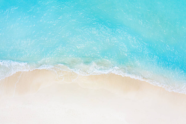 Καλοκαίρι θαλασσογραφία όμορφα κύματα, μπλε νερά στην ηλιόλουστη μέρα. Πάνω άποψη από drone. Θέα στη θάλασσα, καταπληκτική τροπική φύση φόντο. Όμορφη φωτεινή θάλασσα με κύμματα και άμμο παραλία έννοια - Φωτογραφία, εικόνα