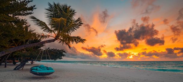 Tropisches Strandpanorama als Sommerlandschaft mit Strandschaukel oder Hängematte, die auf Palmen über weißem Sand und ruhigem Meer für Strandbanner hängen. Perfekte Strand-Szene Urlaub und Sommerurlaub Vorlage. Luxus-Badeort - Foto, Bild