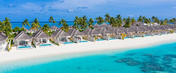 Vista aérea de la isla de Maldivas, lujosas villas acuáticas. Hermoso cielo y fondo de playa laguna oceánica. Vacaciones de verano y concepto de viaje. Paraíso paisaje aéreo pano - Foto, imagen