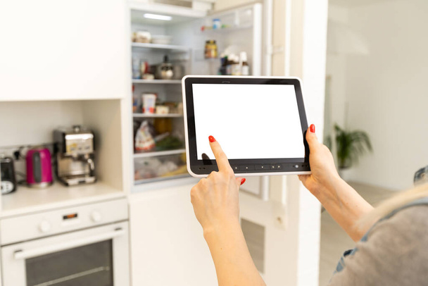 Intelligent home concept. Young woman using smart home application on a tablet - Photo, Image