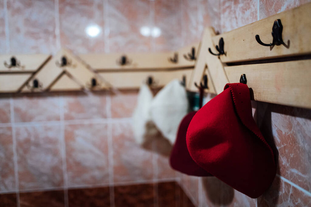 badmutsen hangen aan een hanger. stoombad van de warme sauna voor wellness recreatie. - Foto, afbeelding