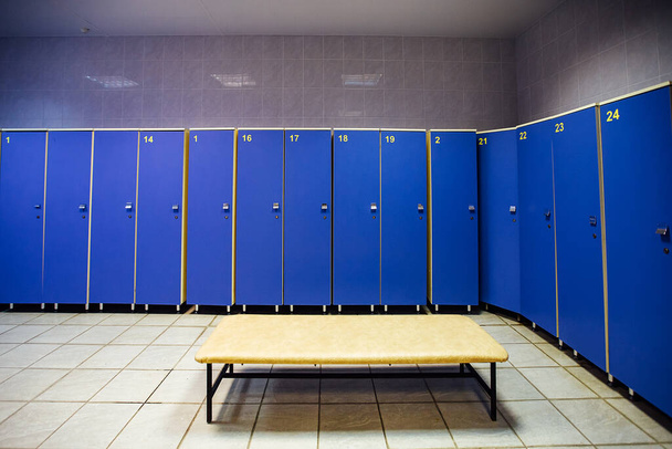 lockers in the gym locker room. bench in front of the shower. a place for athletes to change clothes after a competition and play sports - Photo, Image