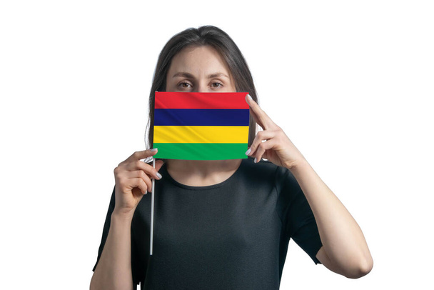 Gelukkige jonge blanke vrouw met vlag Mauritius vlag en bedekt haar gezicht met het geïsoleerd op een witte achtergrond. - Foto, afbeelding