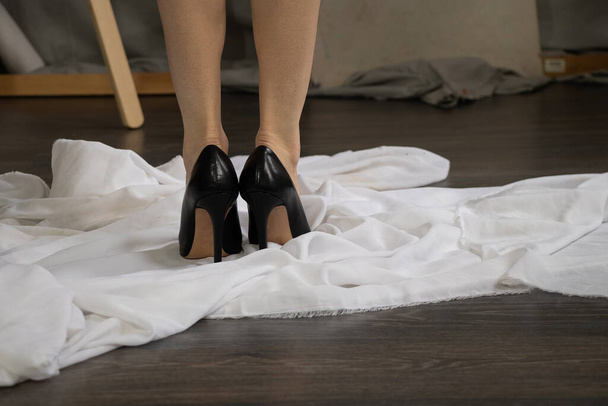 pies de las niñas en zapatos de cuero negro en el suelo en casa, zapatos de mujer con tacones - Foto, Imagen