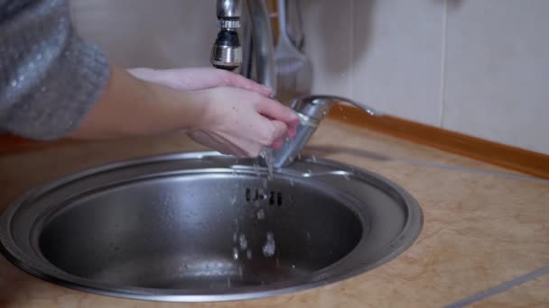 La mujer se lava las manos bajo una fuerte corriente de agua corriente, apaga el grifo. Salpicadura - Imágenes, Vídeo