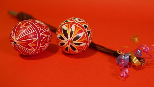 Чешский стержень с разноцветными пасхальными яйцами, красный фон, фото - Фото, изображение