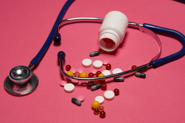 Pillerit valkoinen purkki stetoskooppi terveys ruisku vaaleanpunainen tausta rajattu näkymä - Valokuva, kuva