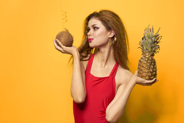 woman with pineapple and coconut cocktail exotic fruits summer lifestyle yellow background - Foto, Imagen
