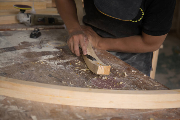 a carpenter using a chisel on a block of wood - Foto, afbeelding