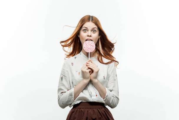 mujer pelirroja con piruleta en las manos emociones diversión dulces estilo de vida - Foto, Imagen