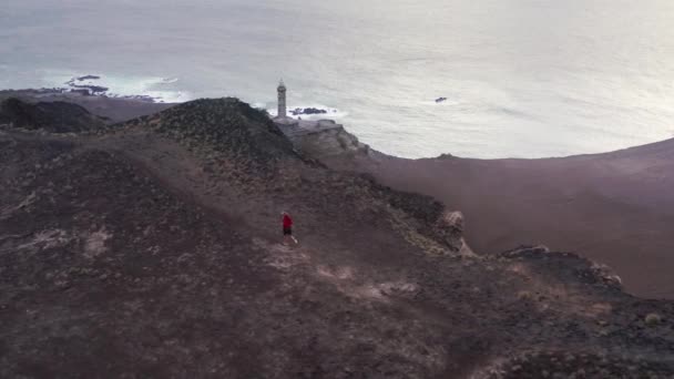  Kerl läuft auf Pfad mit Volcano Interpretation Center von Capelinhos  - Filmmaterial, Video
