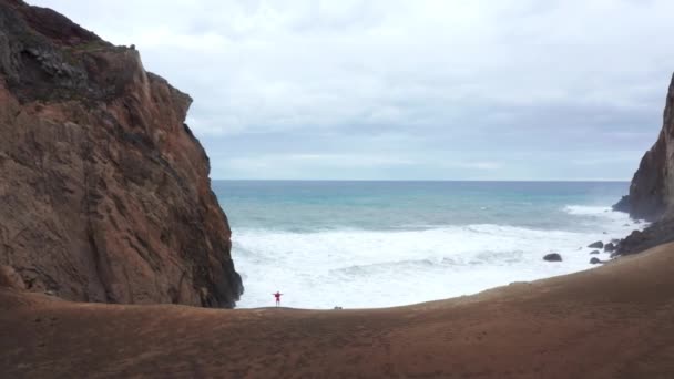 Man standing on cliff at Capelinhos Volcano, Faial Island, Azori-szigetek, Portugália - Felvétel, videó