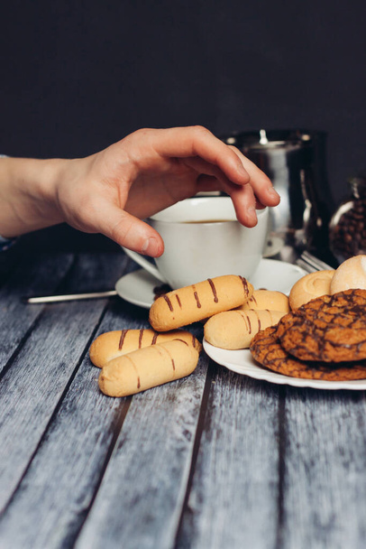 cookies on a plate a cup of tea on a wooden table a snack - Foto, afbeelding