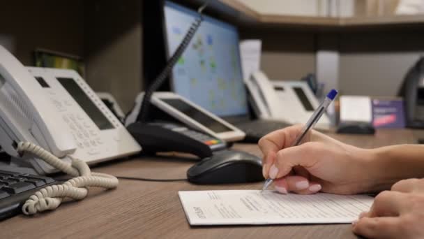 Female secretary or receptionast writing down appointment in notebook. Close-up shot of office life. Doctor filling in patient s registration form, medical reception at hospital. 4 k footage - Footage, Video