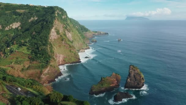 The road tucked away between lush green cliffs and the Atlantic Ocean - Footage, Video