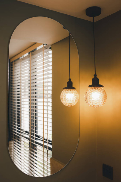 lámpara de techo colgante decorada en la esquina del cuarto de baño con reflexión sobre espejo, concepto de interior - Foto, imagen