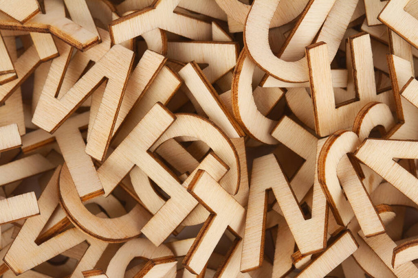 bovenaanzicht close-up detail macro van stapel van hout gesneden kleine alfabet letters - Foto, afbeelding
