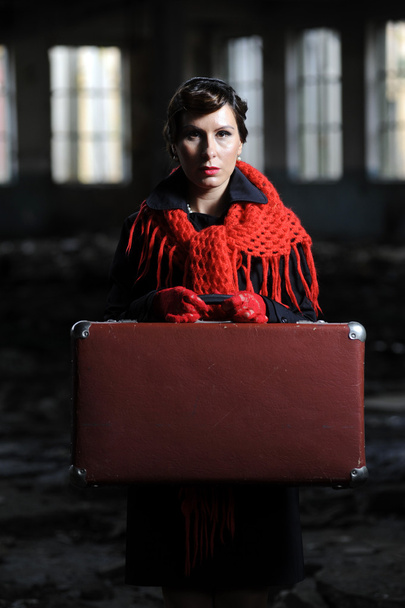 Portrait of retro young woman with a suitcase outdoor - Foto, afbeelding