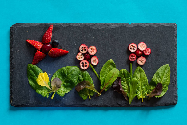 ideas creativas de frutas y verduras en el plato negro, colores verdes y rojos - Foto, imagen