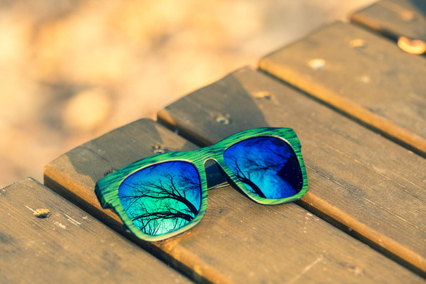 Klasszikus napszemüveg modell kék fényvisszaverő lencsével és zöld kerettel egy napsütéses napon kívül közelkép. Szelektív fókusz - Fotó, kép