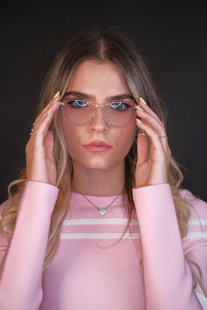 Italian girl with long blond hair posing in studio with eyeglasses. High quality photo - Foto, afbeelding