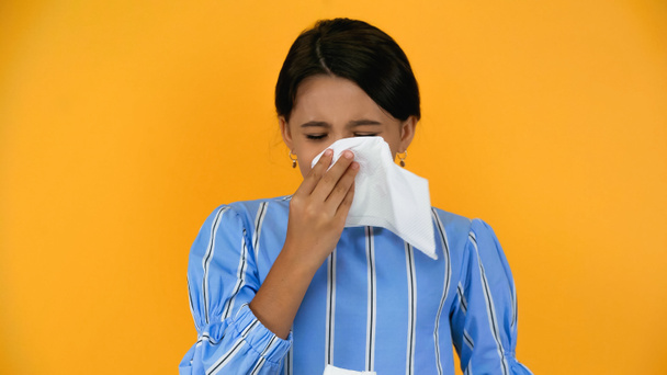 sad sick girl blowing nose with napkin isolated on yellow - Photo, Image
