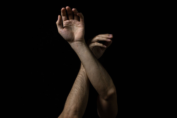 Męskie ręce na czarnym tle. Dwie męskie ręce na ciemnym tle. Części ciała. - Zdjęcie, obraz