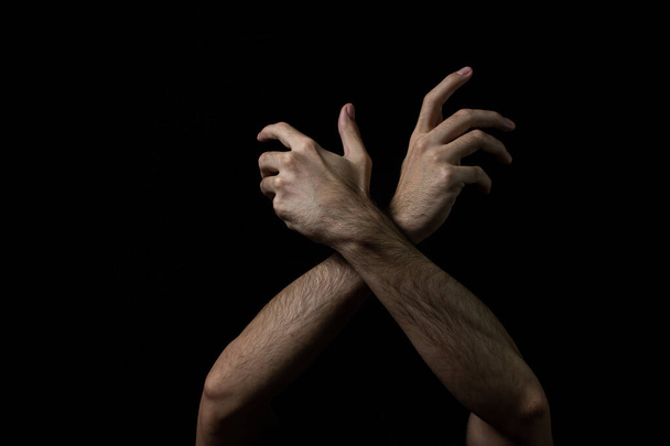 Männliche Hände auf schwarzem Hintergrund. Zwei männliche Hände auf dunklem Hintergrund. Körperteile. - Foto, Bild