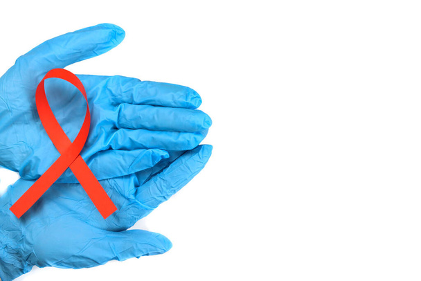piros szalag a kezében elszigetelt fehér alapon, a HIV, az AIDS és a rák elleni küzdelem szimbóluma - Fotó, kép