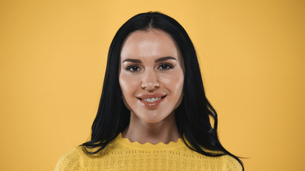 portret radosnej, brunetki uśmiechającej się do kamery odizolowanej na żółto - Zdjęcie, obraz
