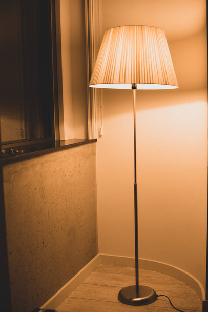 floor lamp with warm light and reflection in the window - Photo, Image