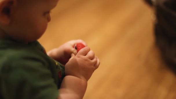 Een klein kind speelt thuis met een speeltje op de vloer - Video