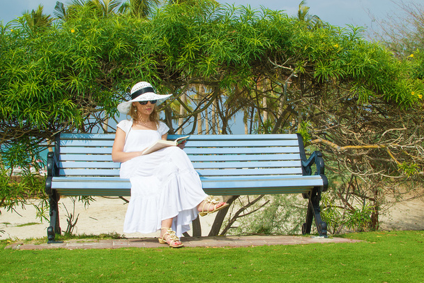 Сексуальная женщина читает в парке рядом с пляжем
 - Фото, изображение