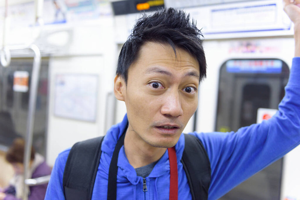 Κοντινό πλάνο για το πρόσωπο του Ασιάτη σοκαρίστηκε όταν έμαθε ότι χάθηκε και πήγε σε λάθος μετρό στην Ιαπωνία.. - Φωτογραφία, εικόνα