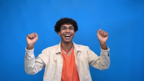 excité afro-américain en lunettes dansant isolé sur bleu - Séquence, vidéo