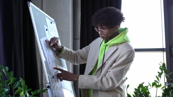 concentrated african american illustrator drawing character in office - Footage, Video