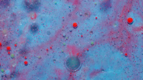Inktbubbels gemengd met vloeibare stof van olie, melk, zeep, heldere acrylverf op kleurrijk oppervlak - Video