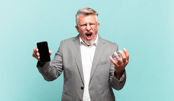 senior businessman looking angry, annoyed and frustrated screaming wtf or whats wrong with you  - 写真・画像