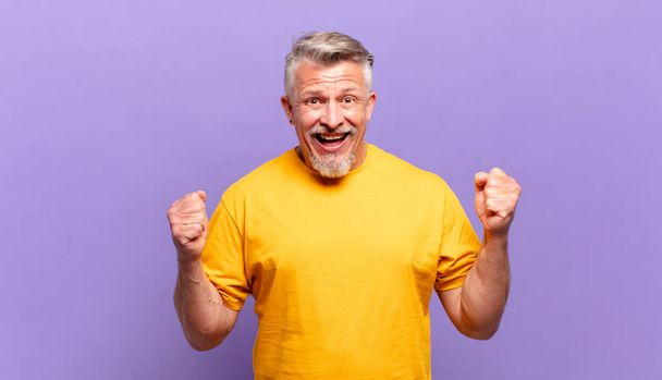 old senior man feeling shocked, excited and happy, laughing and celebrating success, saying wow! - Foto, Imagen