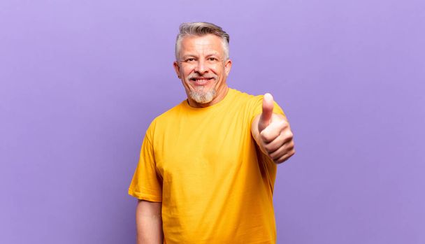 old senior man feeling proud, carefree, confident and happy, smiling positively with thumbs up - Fotoğraf, Görsel