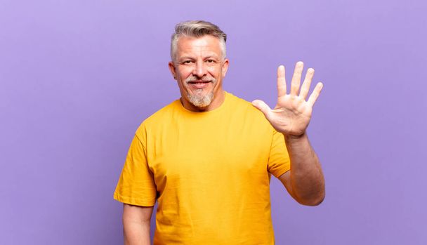 old senior man smiling and looking friendly, showing number five or fifth with hand forward, counting down - Fotoğraf, Görsel