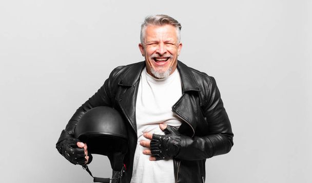 senior motorbike rider laughing out loud at some hilarious joke, feeling happy and cheerful, having fun - Фото, зображення